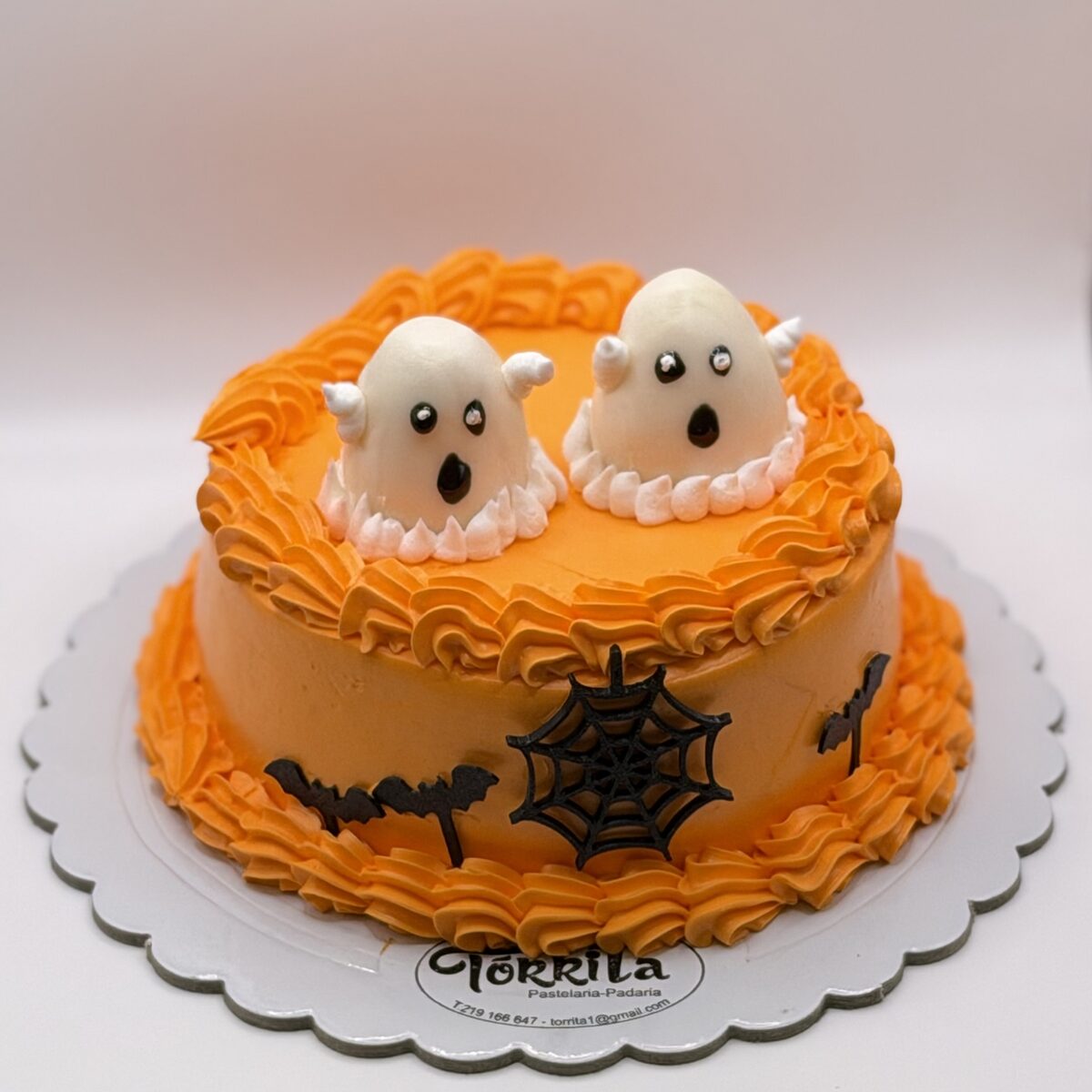 Bolo laranja decorado com fantasmas, morcegos e teia de aranha